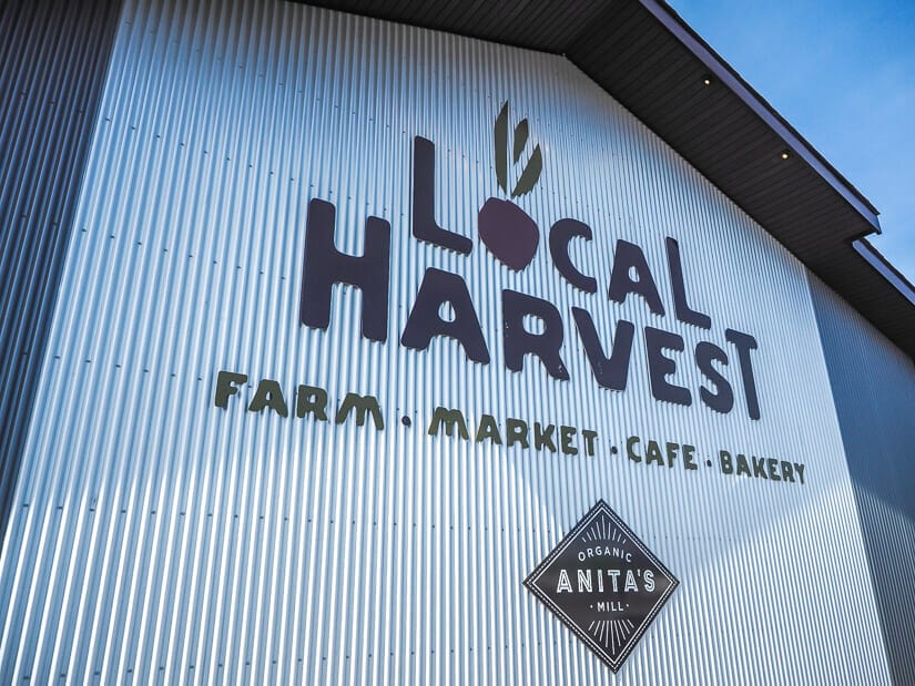 A sign that says "Local Harvest Farm Market Cafe Bakery" and "Anita's Organic Mill"