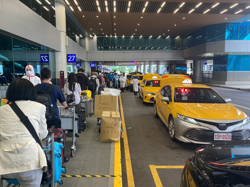 Line of passengers and quarantine taxis outside Taiwan airport