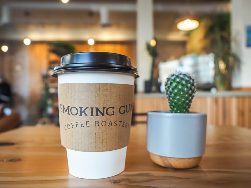 A cup of coffee and small cactus on a table inside Smoking Gun Coffee Roasters, Chilliwack