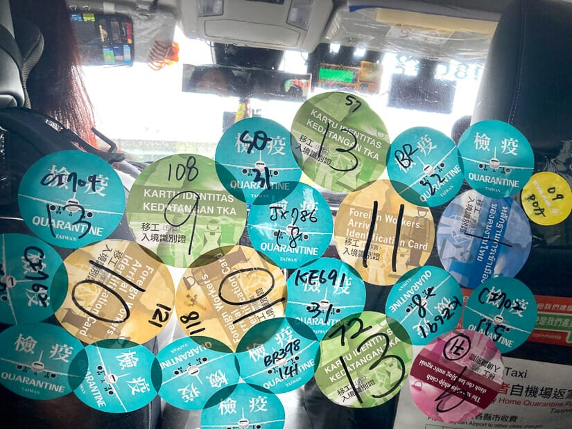 A quarantine taxi's protective panel covered with quarantine stickers from arriving passengers at Taoyuan International Airport