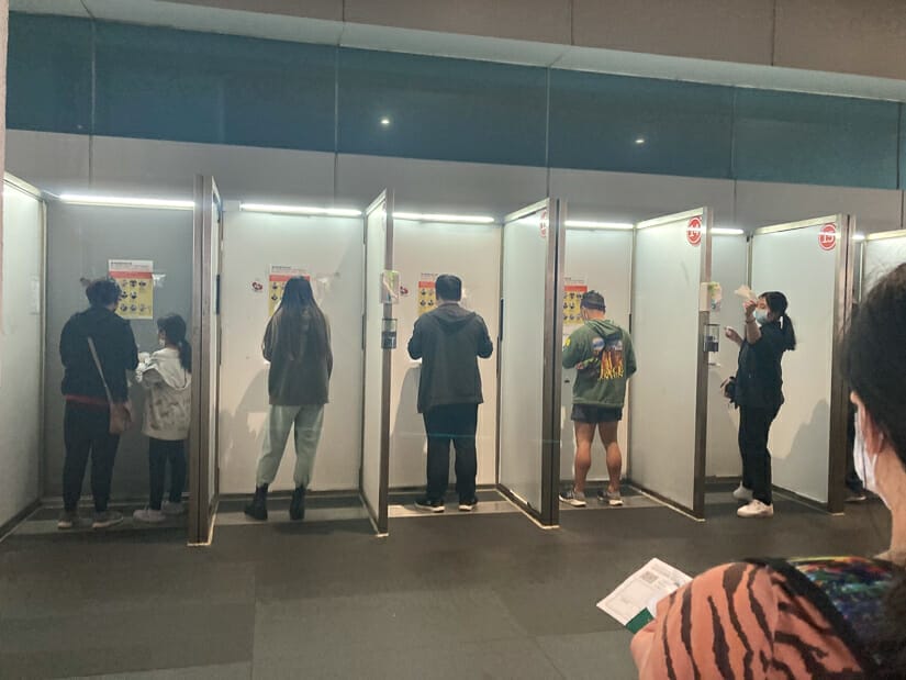 People at COVID saliva testing booths at Taiwan Taoyuan International Airport