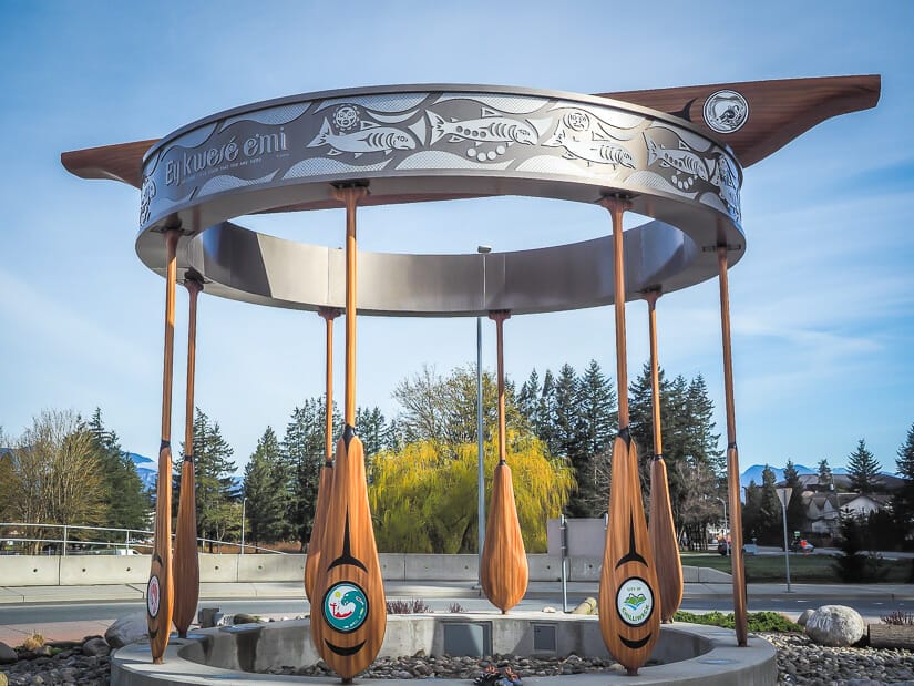 An art installation with canoe, paddles, and indigenous carvings at Vedder Bridge, Chilliwack