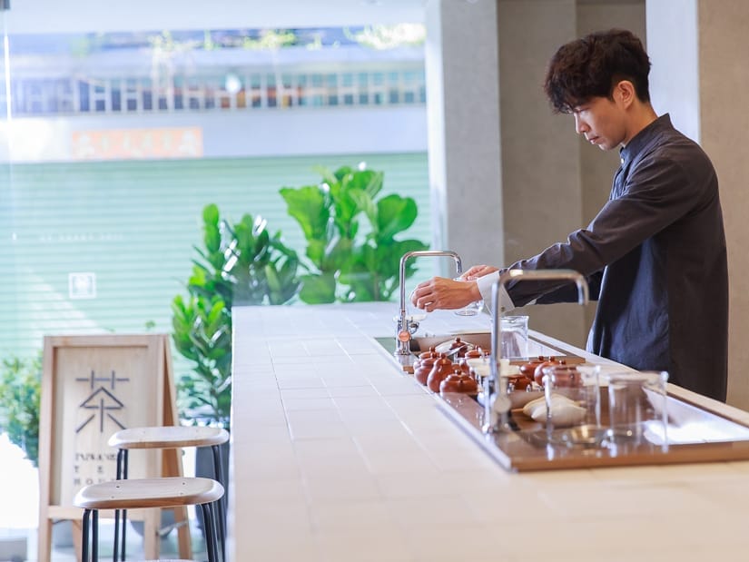 A man pouring tea at a counter inside a tea shop