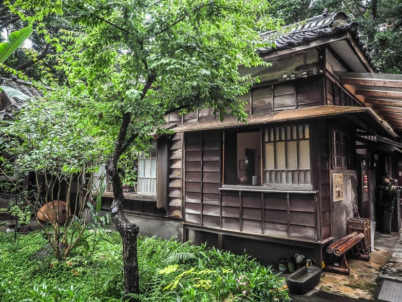 A traditional wooden Japanese house with trees around it