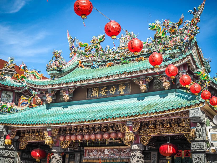 Exterior of Anping Matsu Temple with turquoise roof tiles and red lanterns hanging in the sky
