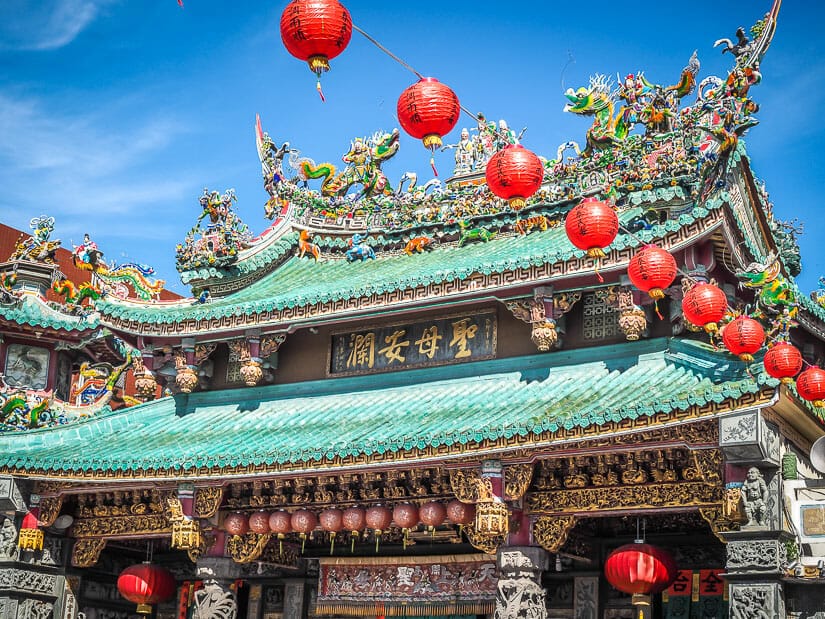 Exterior of Anping Matsu Temple with turquoise roof tiles and red lanterns hanging in the sky