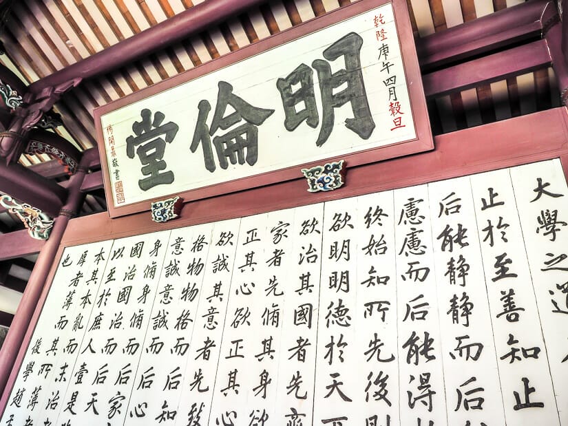 A white board covered in Chinese characters in black calligraphy inside the Tainan Confucius Temple