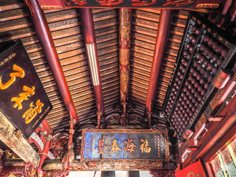 Looking up at the inner ceiling of the Taiwanfu City God Temple in Tainan, with a huge abacus above the doorway on the right