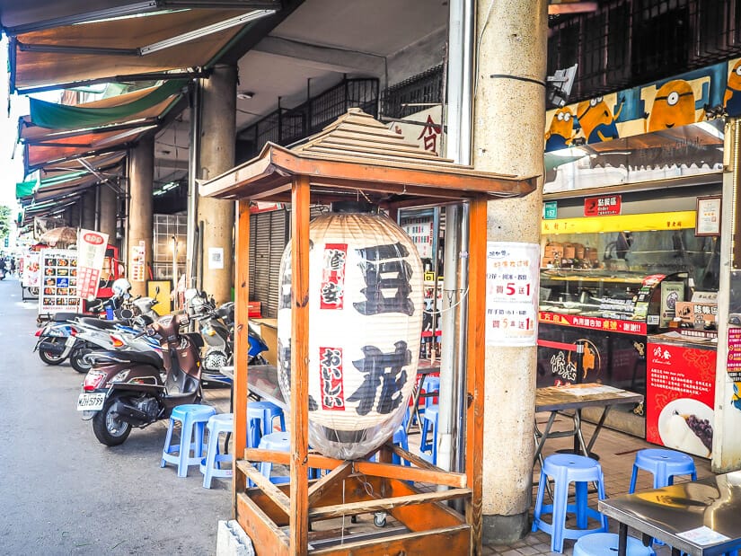A row of hole-in-the-wall restaurants in Yongle Market Tainan, with a traditional Japanese lantern decoration on the street