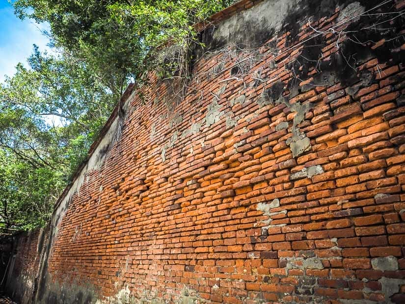 A tall red brick wall on the exterior of Anping Tree House