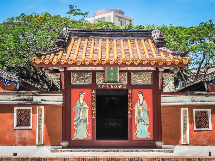 Entrance door and side wings of Wufei, or Five Concubines Temple in Tainan, with trees behind and blue sky above