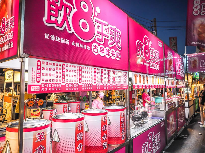 Bright pink iced tea stall signs and vendors at Garden (Flower) Night Market in Tainan