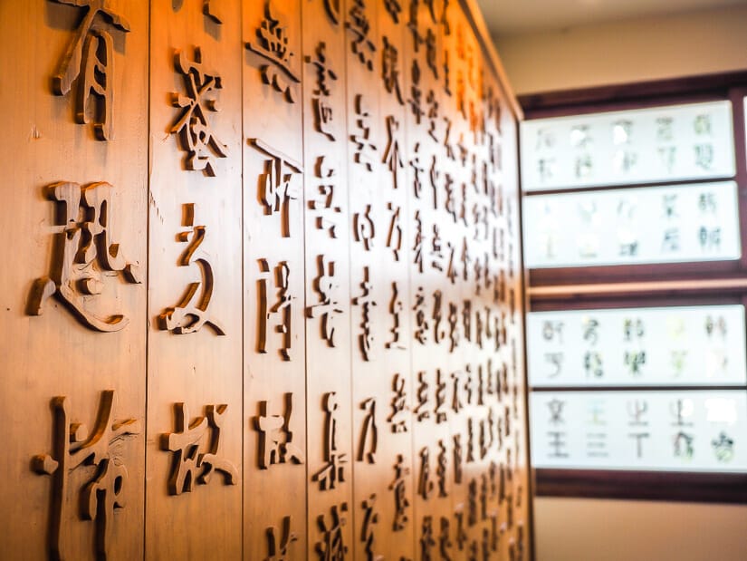 A wall covered in Chinese character calligraphy and Mr. Zhu's Calligraphy and Former Residents, Anping Treehouse