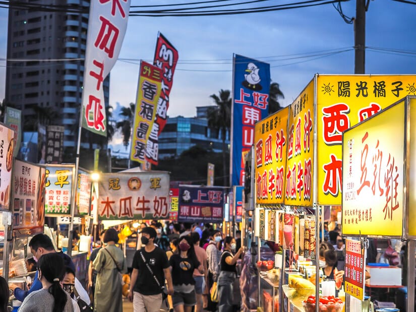 Crowds and food stalls at Dadong Night Market in Tainan with buildings and electrical wires in background