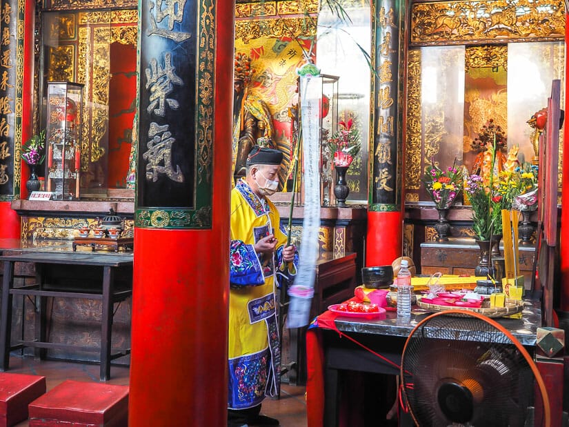 A person dressed in ceremonial attire conducting a ritual inside Tainan's Dongyue Temple