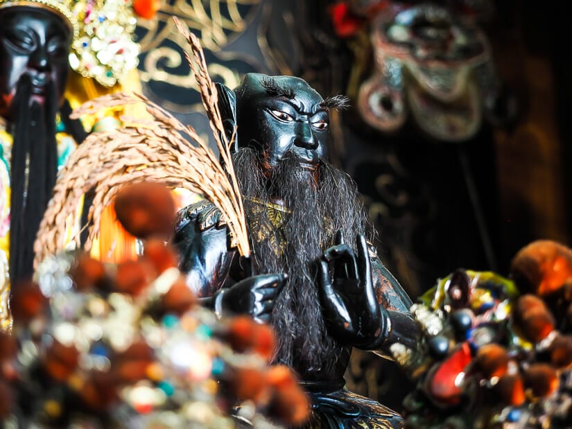 Close up of a black statue, the Medicine God, inside a temple in Tainan