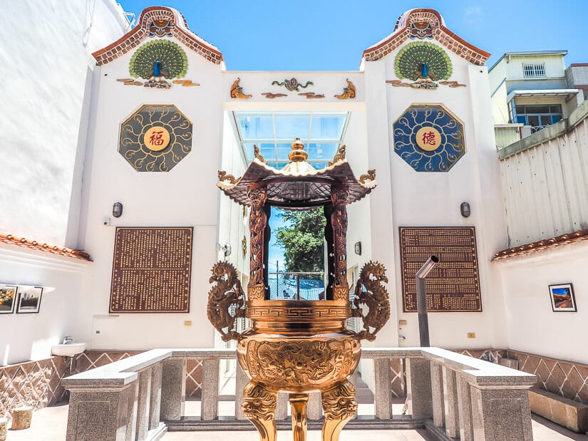 The golden incense shrine of a temple, with white walls around it and an entrance at the back that leads to Anping Old Street
