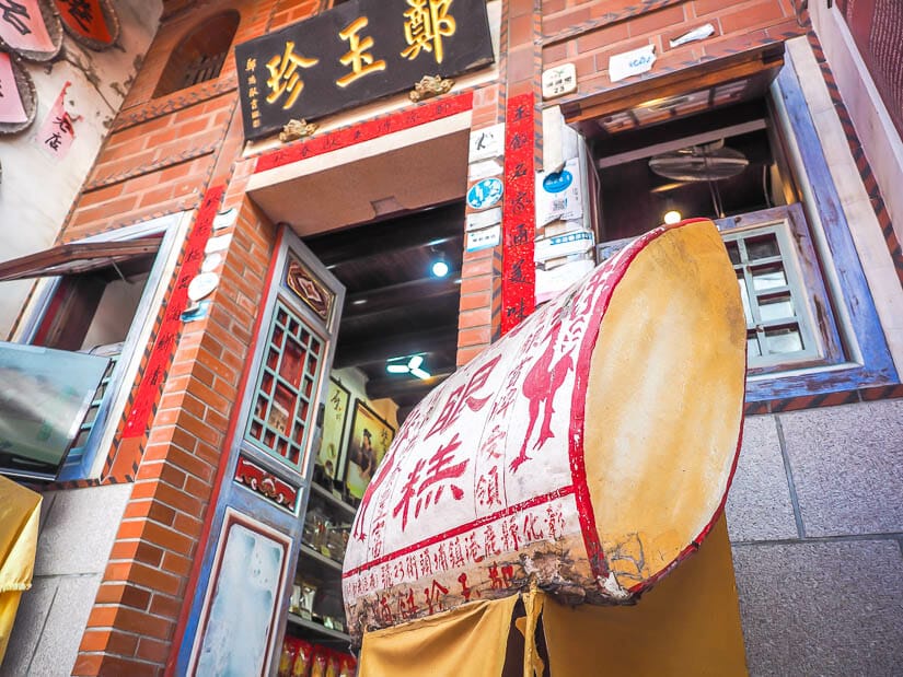 The entrance to a traditional bakery on Lukang Old Street with a statue shaped like a phoenix eye cake