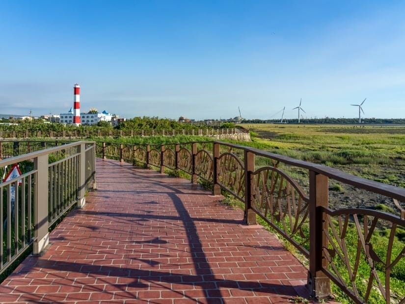 A red brick cycling path with Gaomei Lighthouse in the background