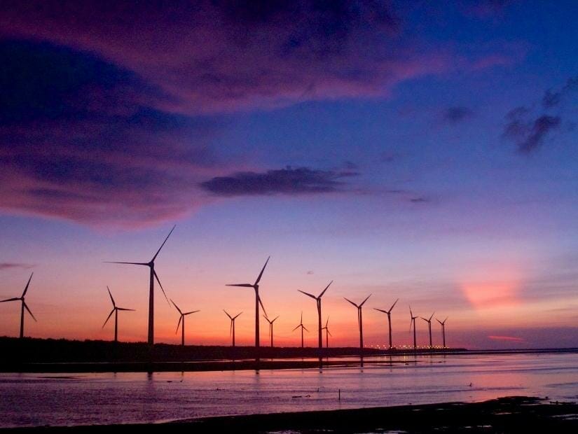 Looking from the shore of Gaomei Wetlands at the sunset and Avenue of Wind Turbines