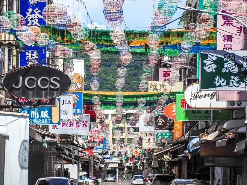 A shopping street with many store signs and lanterns hanging above