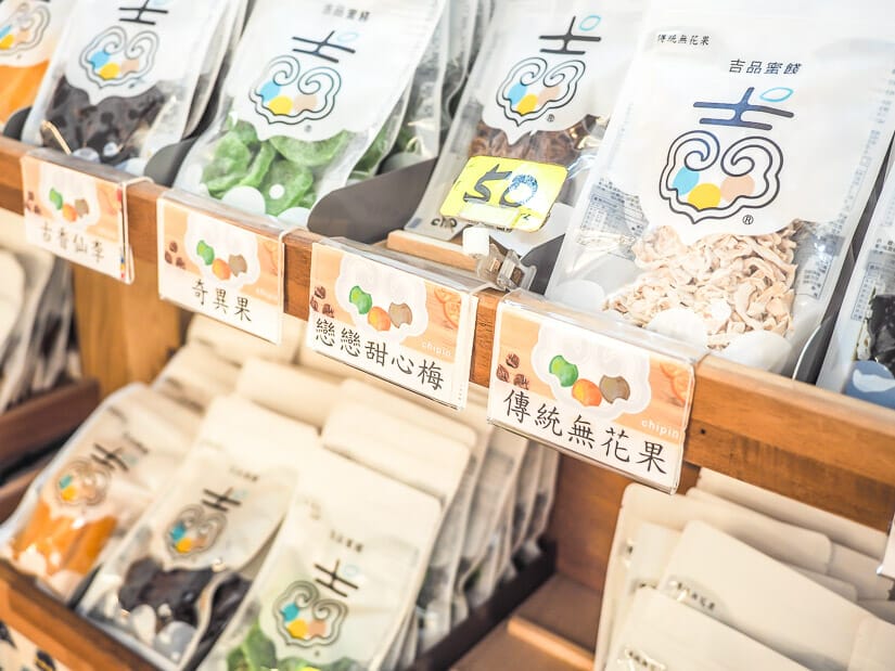 A shelf with white bags of candied fruit for sale