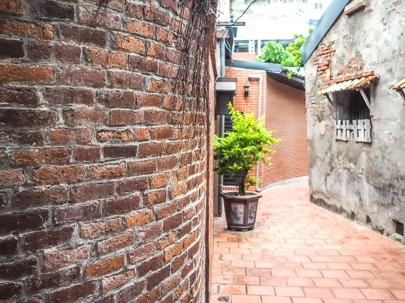 A curving narrow lane in Lukang lined with red brick walls