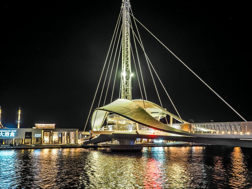 A lit up pedestrian bridge crossing Kaohsiung Port from Pier 2 Art Center to HOLO park