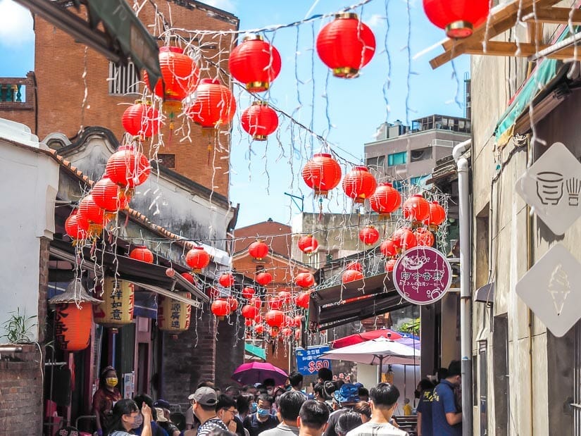 Lukang Old Street, a narrow alley filled with people and with strings of red lanterns hanging above them