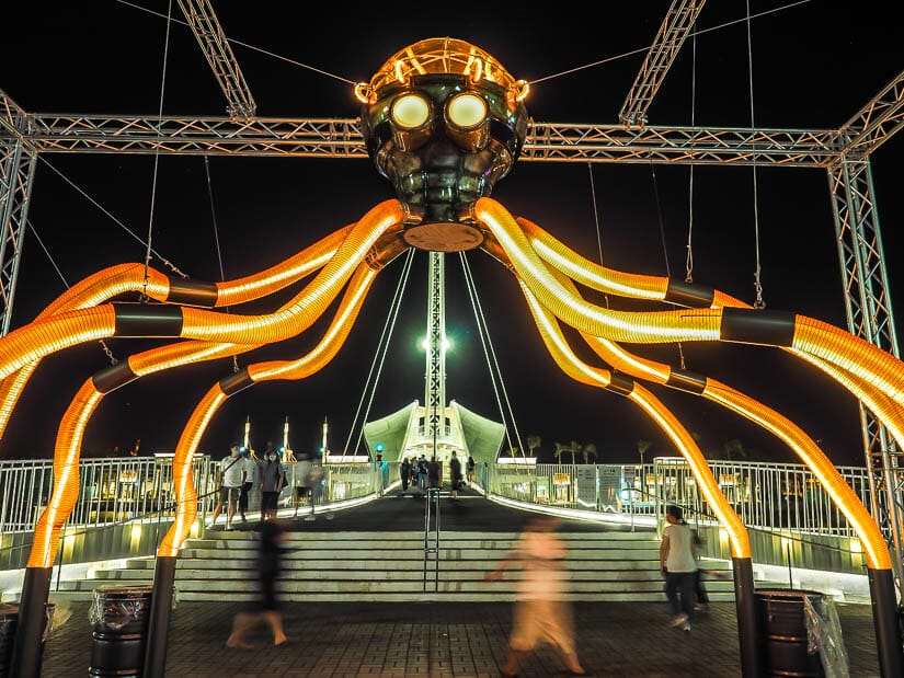 An octopus art installation lit up at night in front of Pier 2 Art Center