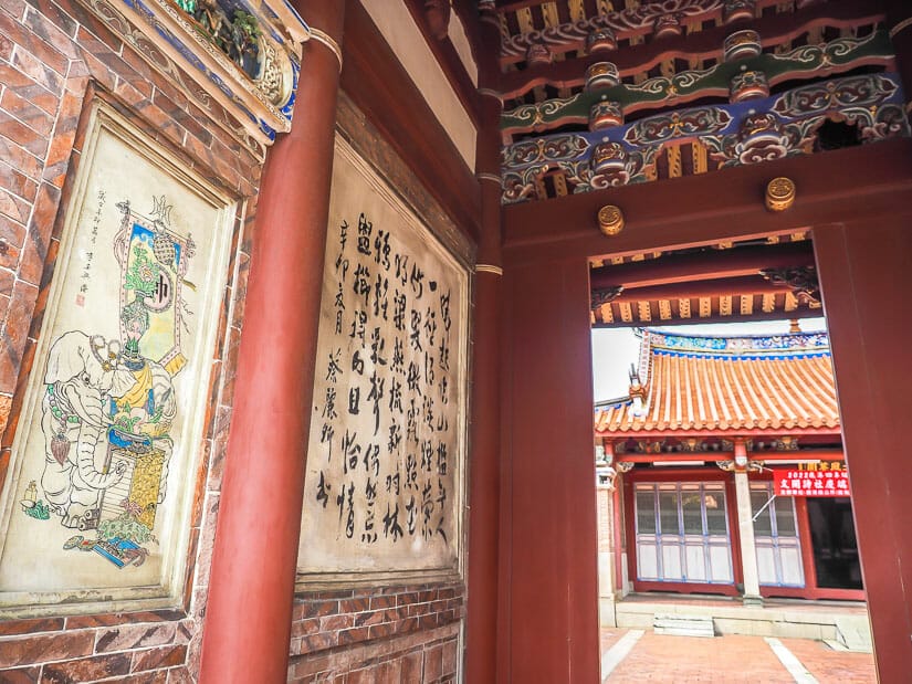 Paintings and calligraphy in the entrance gate of Wenwu Temple in Lukang, with the main temple visible through the doorway