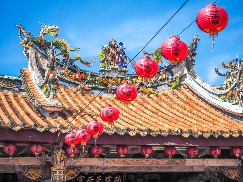 The roof of Xinzu Temple with a string of red lanterns leading to it