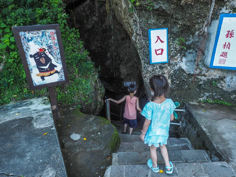Two kids climbing down stairs into Black Dwarf Cave on Liuqiu Island