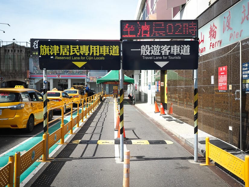Two lanes for bicycles and scooters to enter the ferry to Cijin Island, with a row of taxis on the street next to it