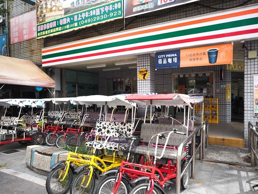Family bikes for rent parked in front of a 7-11 Eleven on Qijin, Kaohsiung