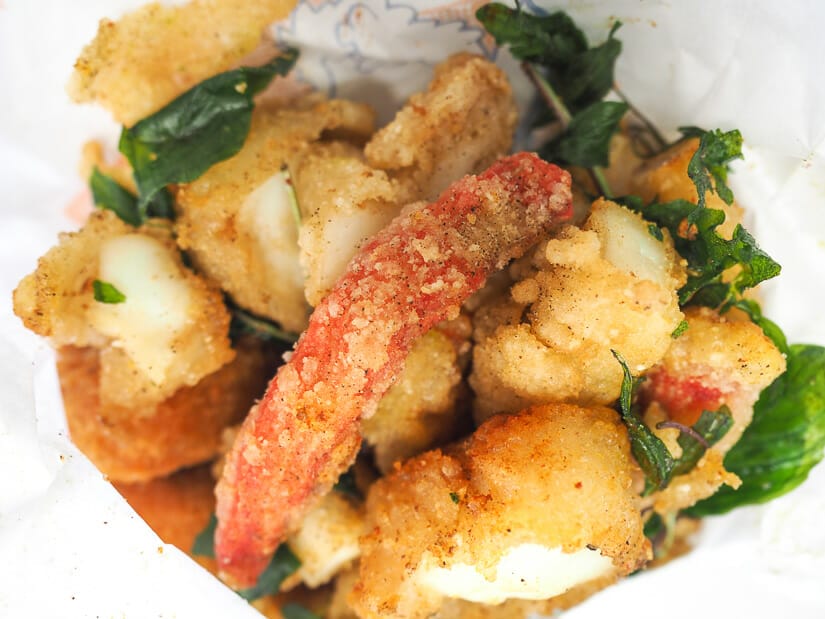 A white paper bag with deep fried seafoods