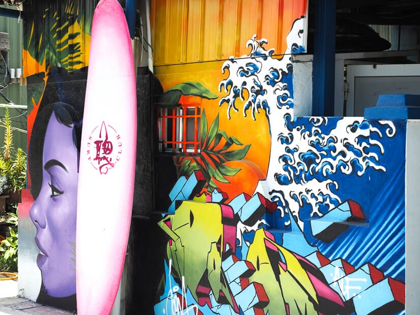 A surfboard standing up against a painted wall at Cijin Surf Bar