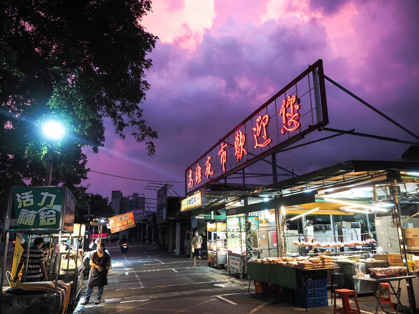 Food stalls at Kaisyuan Night Market with a purple sky
