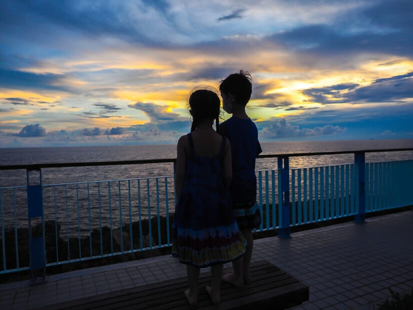Two kids watching the sunset from a sunset viewing platform on Xiaoliuqiu
