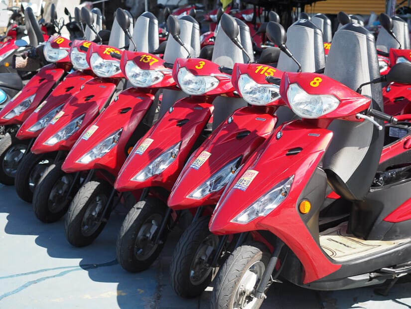 A row of red scooters for rent on Xiaoloiuqiu