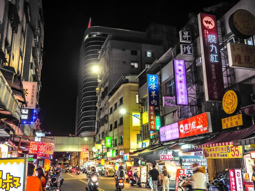 A night market in Sanduo Shopping District, Kaohsiung, with a large mall visible in the background