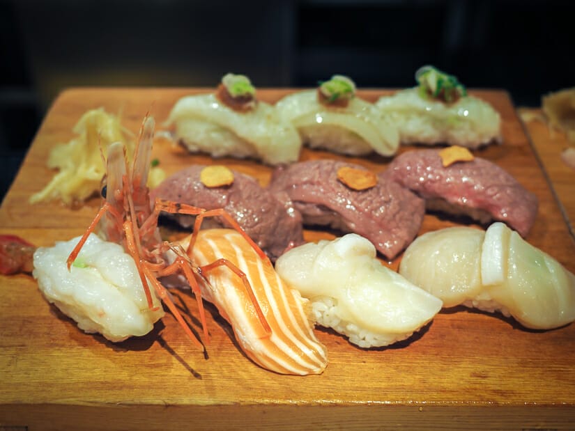 A wooden tray of sushi on the bar at Addiction Aquatic