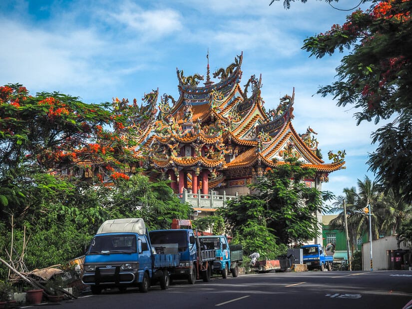 A temple and street with blue trucks on Xiao Liuqiu Island