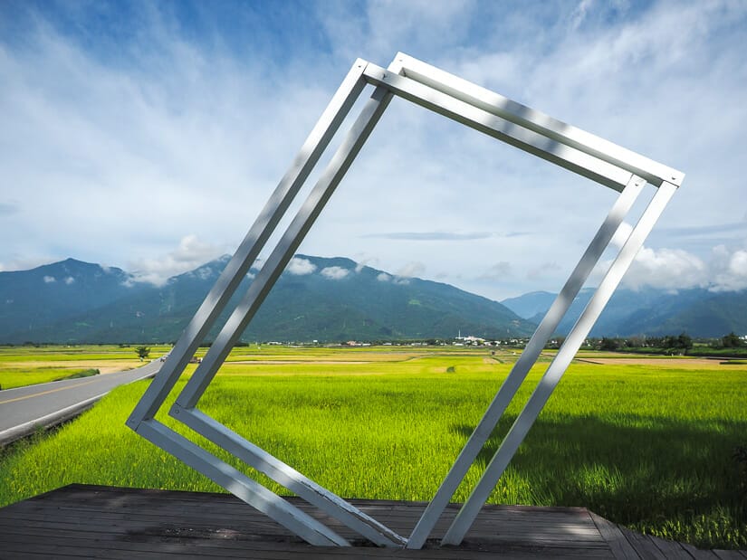 A large metal frame meant for taking selfies with green rice paddies and Brown Boulevard cycling path in the background