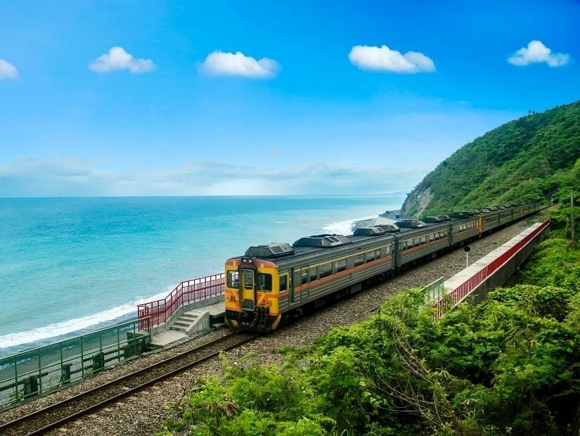 A train parked at Duoliang Railway station, with the ocean in the backgrounfd