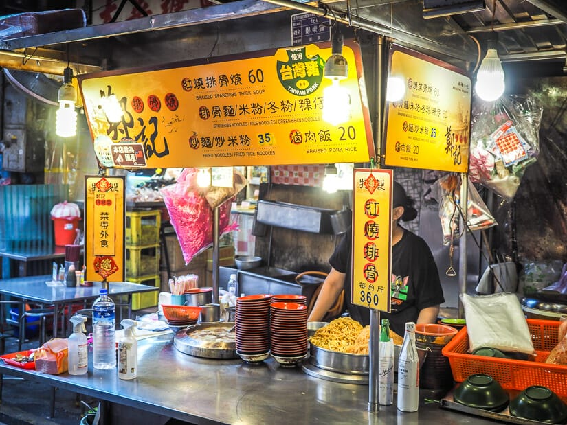 A food stall in Keelung Night Market that sells rib soup with their signs and menu in yellow