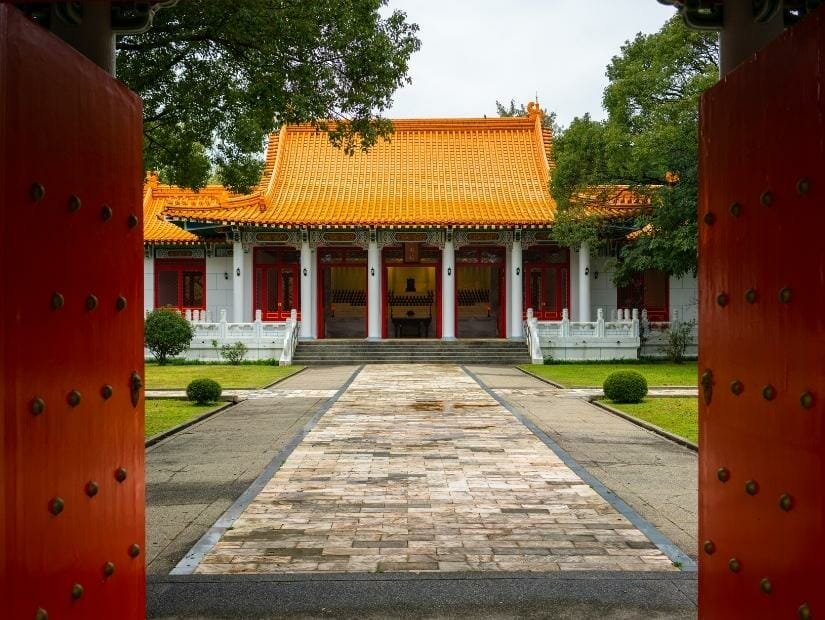 Looking through two large red wooden gates at the main hall of the New Taipei City Martyr's Shrine