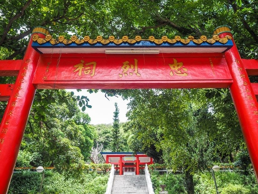 Looking up through a traditional red gate at a set of stairs that lead up to a red shrine called Taitung Martyr's Shrine