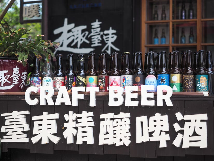 A bar counter at Taitung Railway Village with white letters that say "Craft Beer" and "Taitung craft beer" in Mandarin, with several beer bottles.