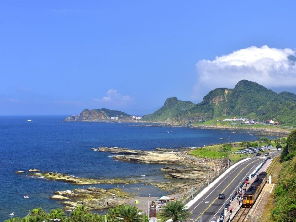 Aerial view of a train at Badouzi station beside the ocean in Keelung